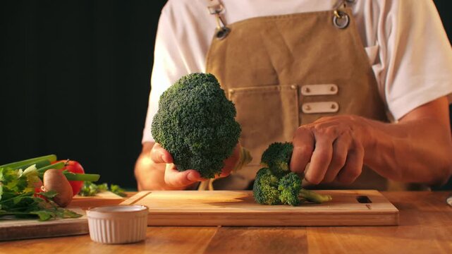 Man chef cooking broccoli, Macro of Broccoli close-up, fresh green broccoli, healthy food, vitamins, raw food and vegetarian lifestyle concept, kitchen vegan food. 