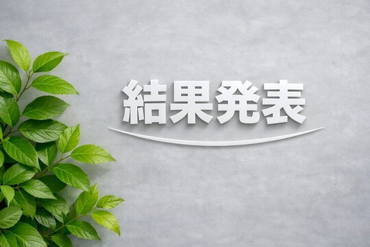 結果発表の文字と緑の葉が映えるコンクリート背景