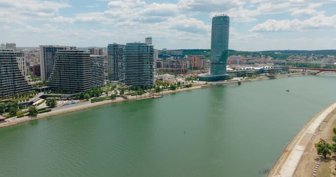 Cinematic 4K drone footage featuring the modern skyline of Belgrade Waterfront and high-rise buildings along the Sava River in Belgrade, Serbia, on a sunny summer day before Expo 2027.