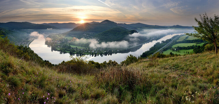 Stunning panoramic sunset over the Elbe river bend with atmospheric valley mist and volcanic hills