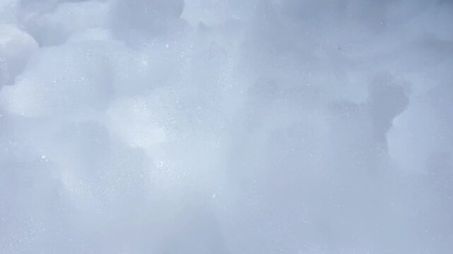 Close-up of fluffy white foam stirring and bending in a gust of wind at a foam party. Foam Party Concept, Entertainment, Summer Vacation. High quality 4k footage