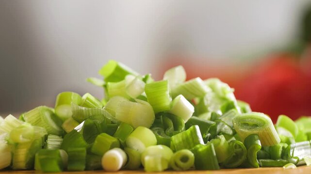Bunch of green onion feathers with drops of water on a cutting board, Close-up macro rotating shot. 