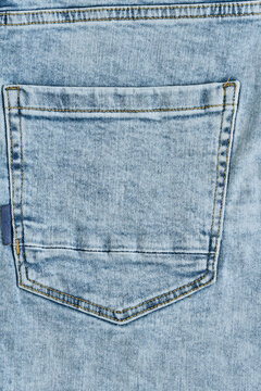 Detailed texture light blue cotton denim fabric with diagonal weave pattern macro close up.