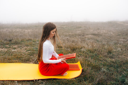 Young woman preparing sadhu nail boards for meditation outdoors