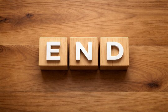 木製ブロックに書かれた「END」文字と温かい木目背景