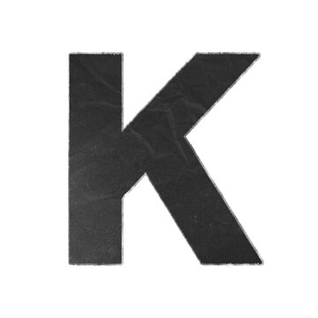 Uppercase letter K cutout from black textured paper with distressed white edges isolated on white background