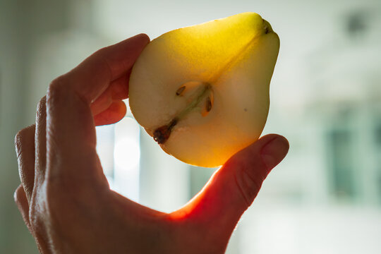 Half pear glowing in warm sunlight revealing translucent fruit texture