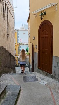 4K video footage of girl walking down the picturesque stairs in streets of Positano on the Amalfi Coast, Italy, featuring colorful buildings, charming narrow lanes and authentic Mediterranean town 