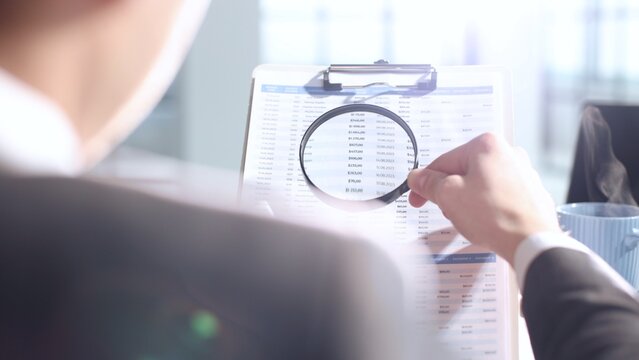 A document verification, magnifying glass, important report