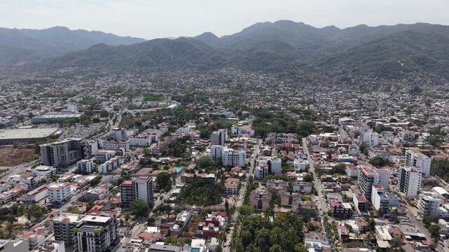 Aerial view with a gentle pan over Versalles neighborhood and mountains in Puerto Vallarta