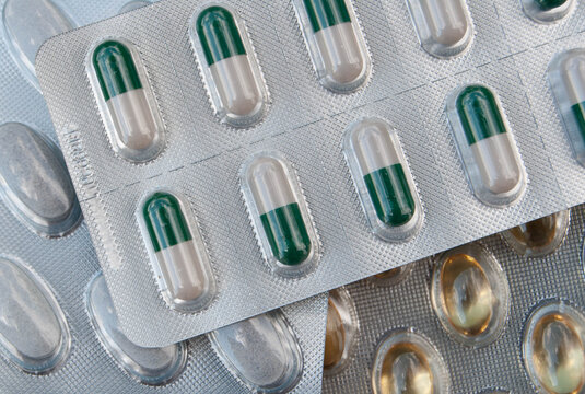 Detailed close-up of omega-3 and iron capsules, showcasing common nutritional supplements in a clean product-style arrangement.