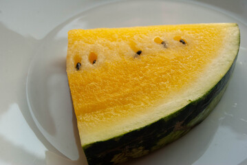 Fresh yellow watermelon slice with detailed juicy pulp, highlighting a unique variety of this refreshing fruit. © Amina