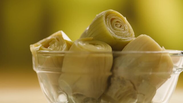 Marinated artichokes in a glass jar isolated on a white background. Mediterranean preserved vegetables, gourmet appetizer, healthy organic food, ready to eat, close-up.