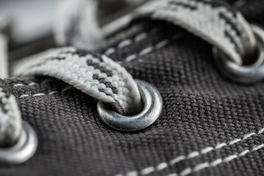 Grey canvas shoe detail with eyelet and patterned shoelace
