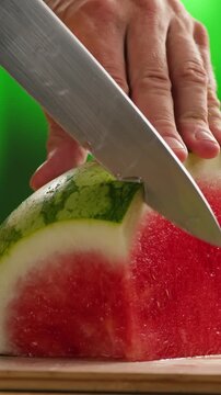 Man cutting watermelon - cut piece with knife. Young watermelons Citrullus lanatus. Topic - melons and gourds, farmer cultivation of watermelons