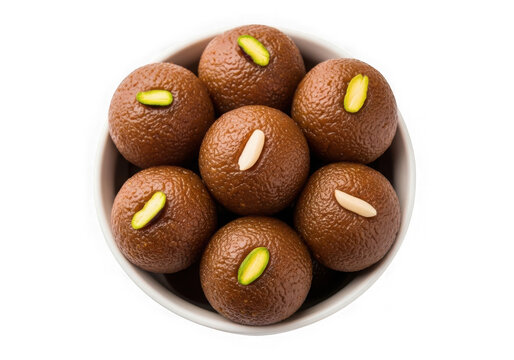 Top view of delicious brown laddoo sweets in a bowl with pistachio topping isolated on transparent background
