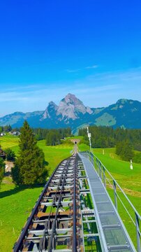 POV riding Stoos funicular railway track descending with view of Mythen mountains in Schwyz, Switzerland
