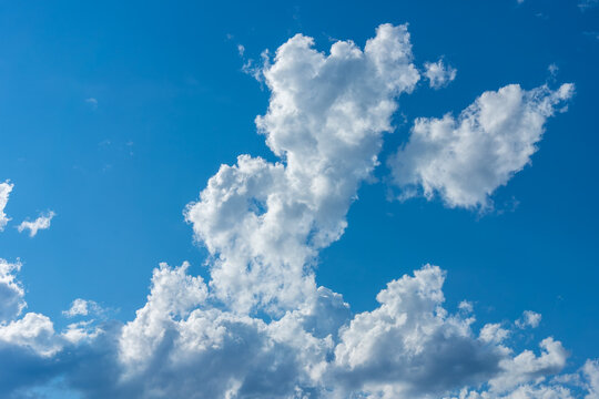 Bright cumulus cloud formation over clear blue summer sky