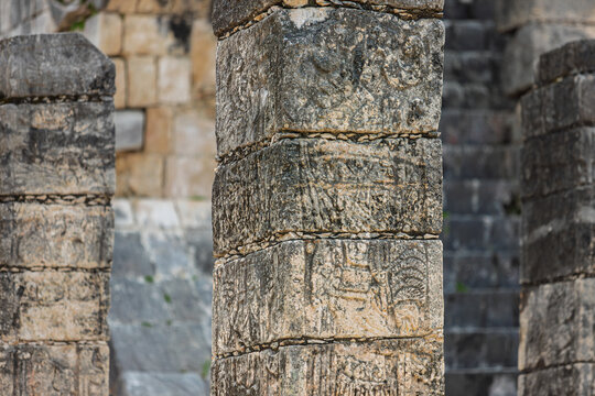 Close up of the intricate stone carvings and glyphs on a column at the Temple of the Warriors in Chichen Itza, Mexico