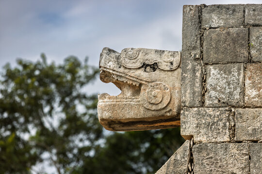 Close up of the carved stone serpent head sculpture at the top of the staircase on the Venus Platform in Chichen Itza, Mexico