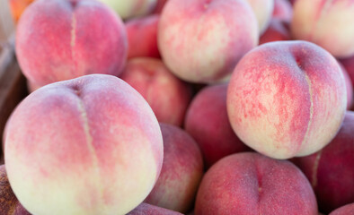 Fresh ripe peaches stacked together, showcasing natural color, texture, and seasonal freshness © Marina