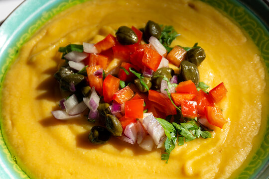 Macro shot of Greek fava split pea dip topped with capers diced tomato and onions
