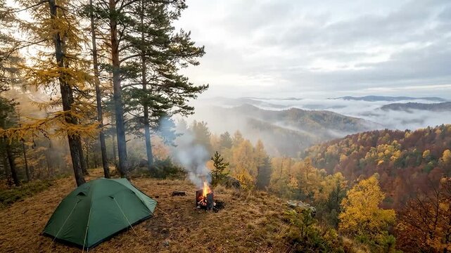 Cozy Autumn Mountain Camping with a Classic Dome Tent and a Softly Burning Campfire in a Foggy Pine Forest