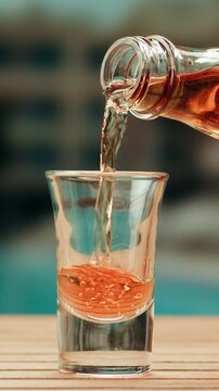 Pouring shot of red bitter, Cognac, whisky, Campari, Aperol, Cherry Vermouth Negroni, spanish wine drink, Alcoholic Americano Cocktail bitter, sweet vermouth and soda water, close up of making drink