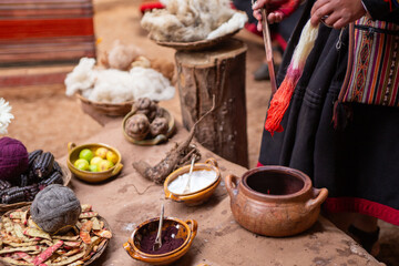 Peruvian artisan demonstrating gradient wool dyeing at a workshop table. © InversedSlayer
