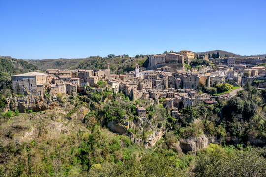 Panorama of Sorano perched on tufa cliffs above a green gorge, Tuscany, Italy