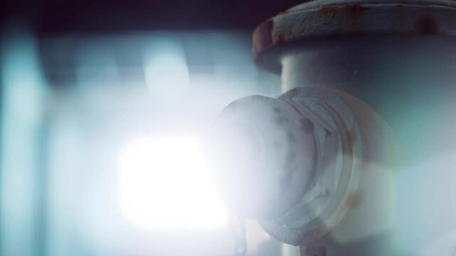 A close view of a fire hydrant shows rust and wear. The setting is an urban environment with low light. The hydrants chain hangs loosely, indicating use.