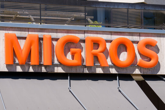Migros supermarket logo sign on store building facade in Lugano