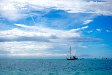 Obraz premium Sailboats Anchored in Open Turquoise Ocean Under Blue Sky