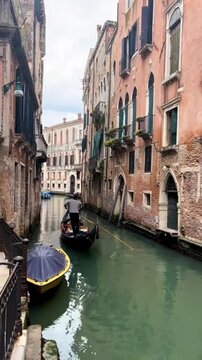 Traditional Gondola Sailing Through Historic Venice Canal Italy
