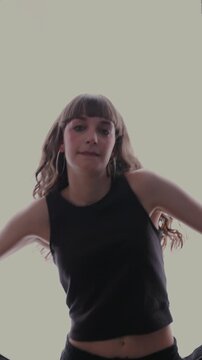Young energetic woman dancing on white background