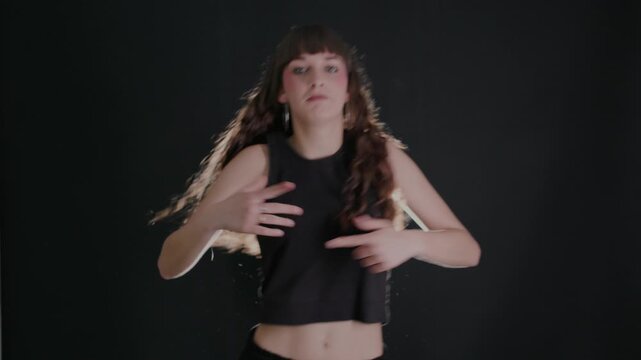 Expressive woman dancing hip hop style in a studio