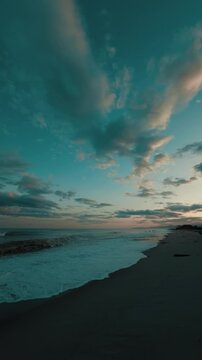 Romantic sky with ocean waves crashing on the beach in the evening