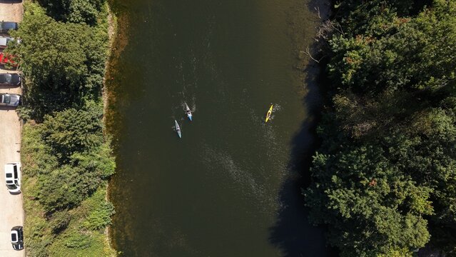 Top-down drone view of kayakers paddling along the River Wye at Symonds Yat near Ross-on-Wye, Herefordshire, England. The overhead aerial perspective captures people enjoying kayaking on calm water 
