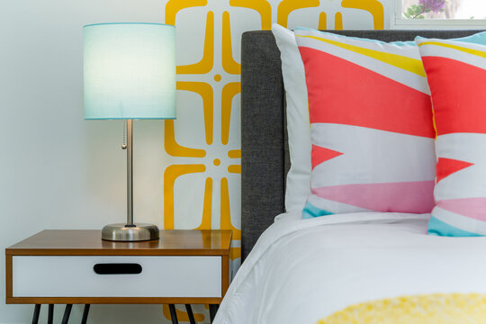 Close-up of a Colorful Geometric Bedroom with Teal Lamp and Nightstand