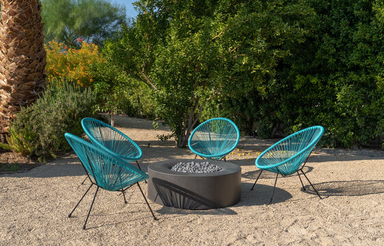 Outdoor chairs and fire pit in desert landscape yard during the day