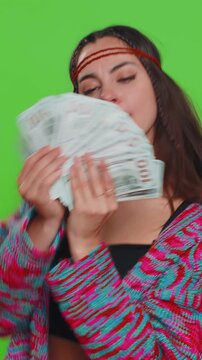 Rich pleased boss young woman waving money dollar cash banknotes bills like a fan, success business career, lottery winner, big income, wealth. Hippie lady isolated on green chroma key background