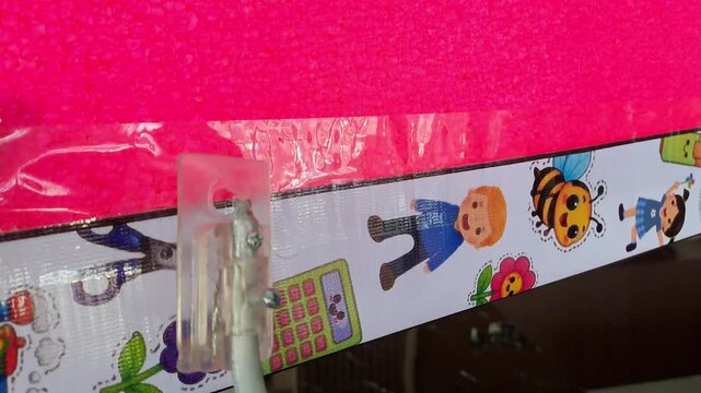 4K footage of DIY hot wire foam cutter tool using thin heated wire powered by 4 batteries. Cutting pink styrofoam board. Process of craft, DIY, hobby, education and handmade tool demonstration.