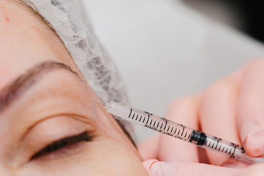 Las manos aplicando na dosis de botox 