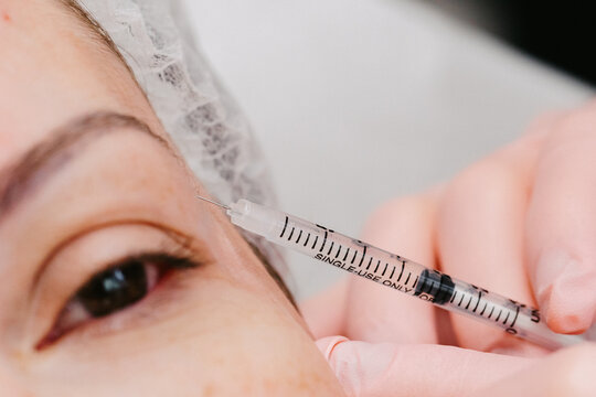 Close up jeringa botox de manos dermatologa
