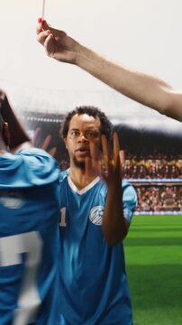 Vertical composition: Soccer referee holding yellow and red cards after a foul, sanctioning disciplinary action and foul sanction on pitch, player sent off in controversy.