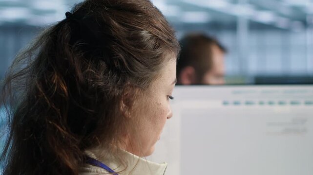 Smiling woman checks server bottlenecks at a PC in a high tech data center, connecting firewall issues, sluggish data transfer and technical troubleshooting.