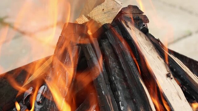 Glowing hot charcoal in barbecue grill pit with open flames close up background texture for bbq cooking and outdoor fire concept