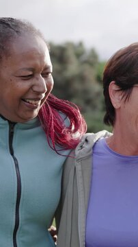 Multiracial senior people have fun hugging each other after yoga class outdoor at park city - Elderly community concept - Vertical video