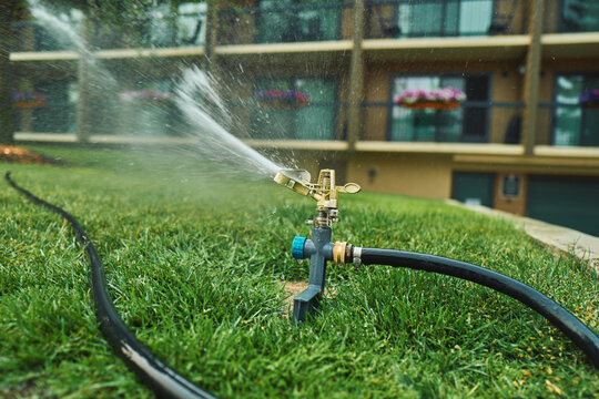Impact sprinkler watering a lush green lawn