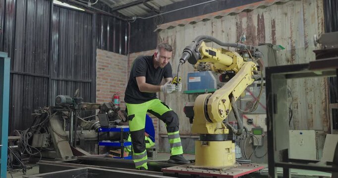 Technicians Troubleshoot Robotic Arm Control System for Automation Maintenance